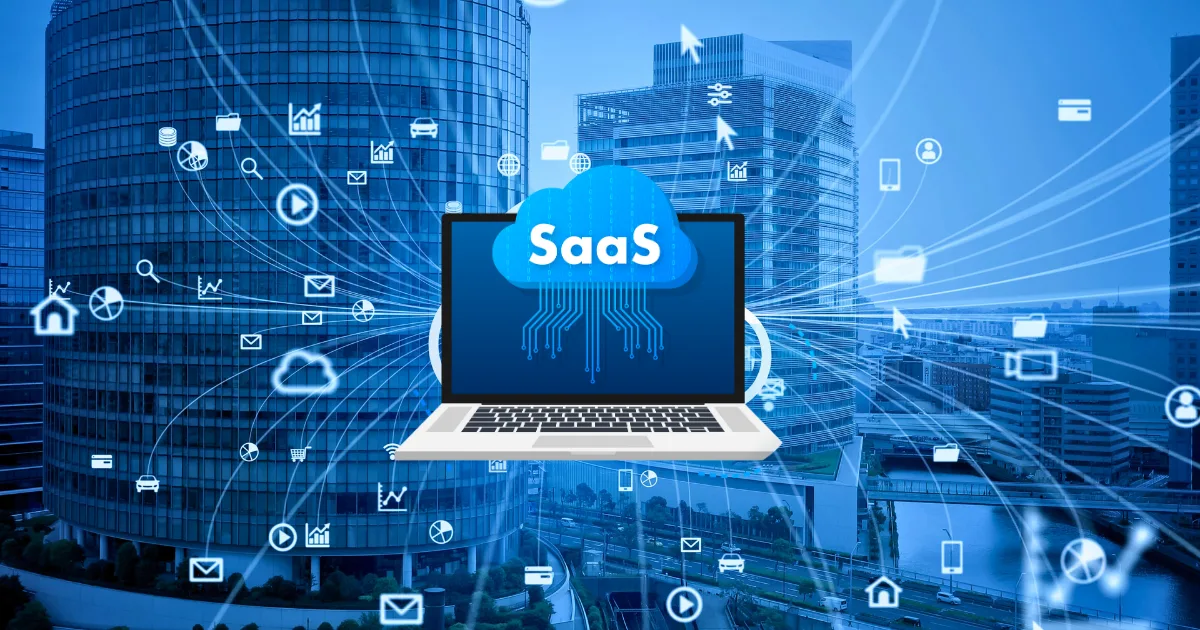A laptop with a SaaS cloud graphic on its screen sits against a cityscape, surrounded by digital icons representing cloud computing and online services, symbolizing affordable SaaS on a budget connectivity.