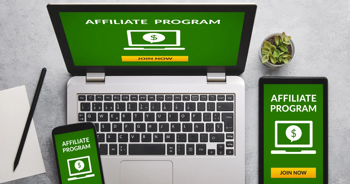 A laptop, smartphone, and tablet display a green screen with AFFILIATE PROGRAM and a Join Now button. A notepad outlines affiliate program selection criteria beside the laptop on a gray surface, next to a small plant.
