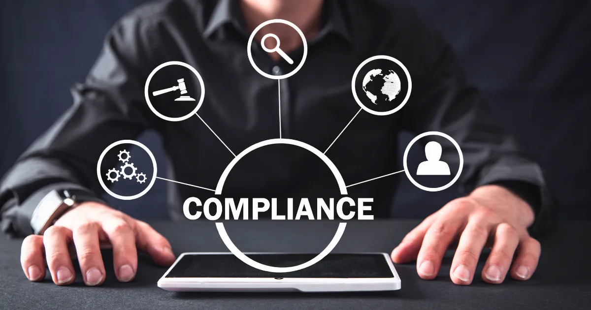 A person sits at a table with a tablet. Above the tablet, "COMPLIANCE" appears in a circle, connected to five icons—law, gears, magnifying glass, globe, and user—suggesting steps on a legal compliance checklist.