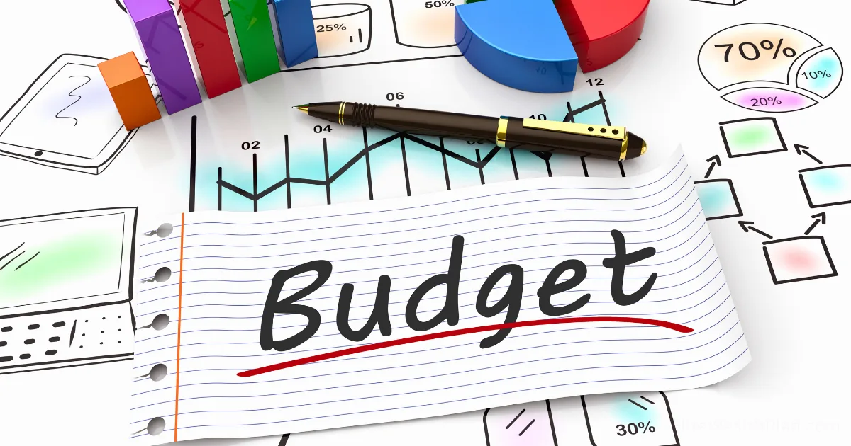 A sheet of paper with the word Budget written on it rests atop financial charts, colorful pie graphs, and a pen—suggesting strategic financial planning or zero-based budget analysis for business owners.